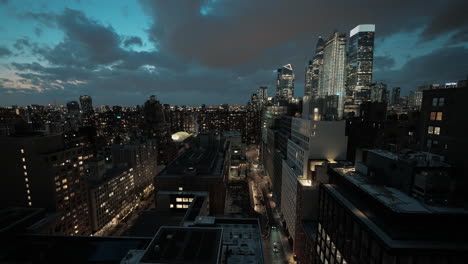Manhattan,-New-York-skyline-at-night-with-bustling-streets,-moving-cars,-pedestrians,-and-dark-clouds-overhead