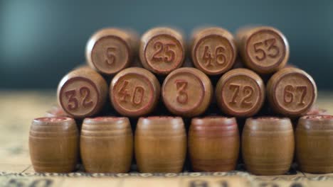 Cinematic-creative-smooth-dreamy-macro-shot-of-Bingo-wooden-barrels-in-a-row,-woody-figures,-old-numbers-background,-vintage-board-game,-slow-motion-120-fps-commercial-gimbal-video,-crane-slide-right