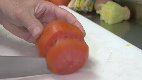 Nahaufnahme-Der-Hände-Des-Küchenchefs,-Die-Eine-Tomate-Schneiden