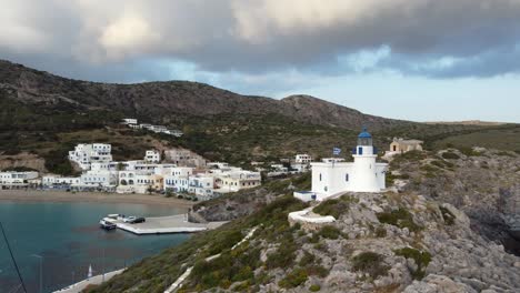 Kapsali-Beach-Bay-Village-with-Lighthouse-and-Greece-Flag,-Kythira-Greek-Island
