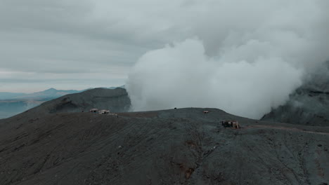 Aerial-view-of-Mount-Aso-in-Japan,-capturing-smoke-from-the-volcano,-filmed-by-a-drone-for-a-cinematic-effect