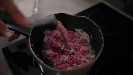 Close-up-shot-of-hands-mixing-ground-turkey-with-onion-in-a-pot-on-the-stove,-minced-meat,-halal-food,-healthy-eating,-cooking-lunch,-dinner,-protein-rich-diet,-fitness-meal-plan,-fresh-ingredient