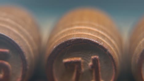 Cinematic-macro-smooth-shot-of-Bingo-wooden-barrels-in-a-row,-woody-figures,-old-numbers-vintage-board-game,-lucky-number-71,-slow-motion,-4K-commercial-gimbal-movement,-dreamy-lighting,-tilt-up
