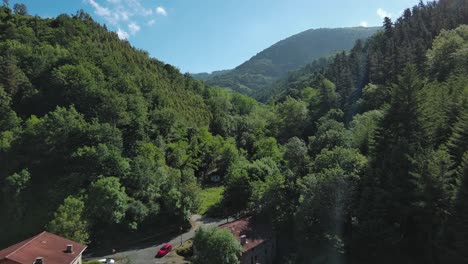 Dorf-Im-Baskenland,-Eingebettet-In-üppige-Grüne-Berge-Unter-Blauem-Himmel,-Luftaufnahme