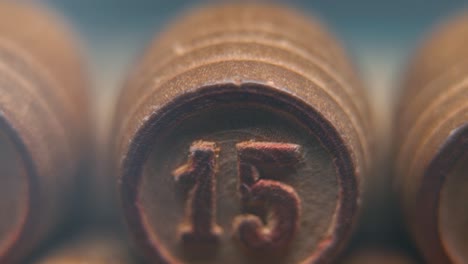 Cinematic-macro-smooth-shot-of-Bingo-wooden-barrels-in-a-row,-woody-figures,-old-numbers-vintage-board-game,-lucky-number-15,-slow-motion,-4K-commercial-gimbal-movement,-dreamy-lighting,-tilt-up