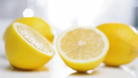 Dolly-in-toward-fresh-lemons-on-white-table,-Selective-focus,-Fruit-concept