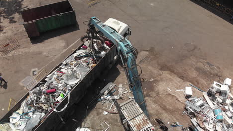 Garbage-crane-loading-a-truck-with-debris-from-a-junkyard