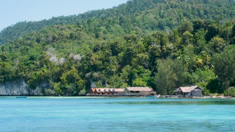 Malerische-Landschaftsansicht-Traditioneller-Hölzerner-Strandhütten-Mit-Blick-Auf-Das-Meerwasser-Auf-Einer-Tropischen-Insel-In-Raja-Ampat,-West-Papua,-Indonesien