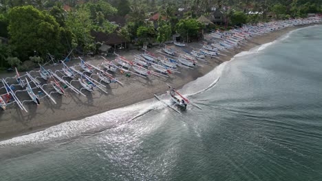 Vista-Por-Drones-De-Un-Barco-Pesquero-Tradicional-Que-Desembarca-En-Una-Playa-Con-Duzzens-De-Barcos-Pesqueros-Tradicionales