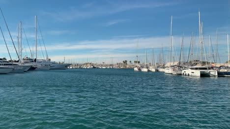 Navigation-channel-with-docks-full-of-sailboats-and-yachts-in-the-port-of-Valencia,-Spain