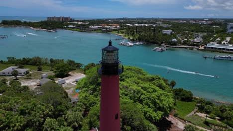 Drohnenaufnahme-Des-Jupiter-Leuchtturms-In-Florida,-Während-Boote-Im-Meer-Vorbeifahren