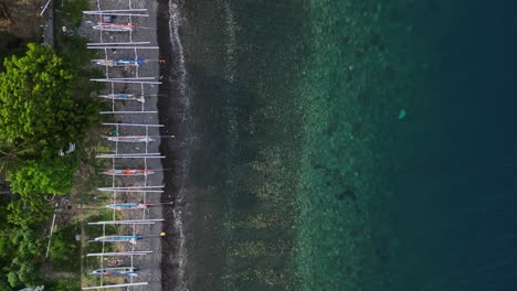 Drohnenansicht-Von-Oben-Nach-Unten-Auf-Einen-Strand-Mit-Kristallklarem-Wasser-Und-Vielen-Traditionellen-Fischbooten