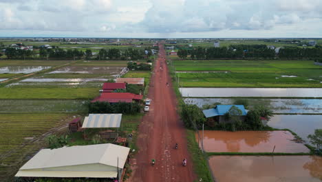 Scooters-Drive-Down-Empty-Red-Dirt-Road-In-Siem-Reap-Countryside-Cambodia