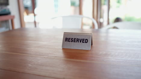 Close-up-of-reserved-sign-on-the-cafe-table-restaurant-during-daytime