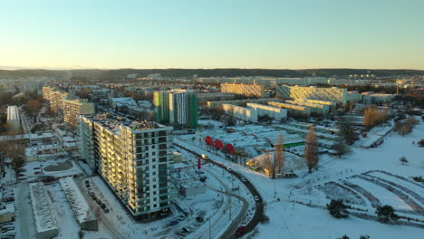 Aerial-establishing-drone-shot-of-polish-block-neighborhood-with-cars-on-road-during-snowy-winter-day-at-sunset-in-Gdansk