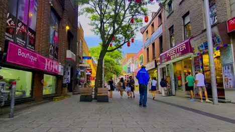 French-Chinese-bilingual-retail-store-shops-in-a-pedestrian-only-street-summer-afternoon-in-Montreal-Canada-where-tourists-shop-calmly-interacting-with-local-malnourished-people-with-poverty-issues