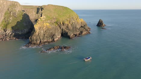 Barco-De-Pesca-Con-Drones-Trabajando-En-La-Escarpada-Costa-De-Waterford,-Irlanda,-Tranquila-Belleza-En-La-Naturaleza.