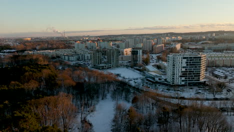 A-distant-view-of-the-Przymorze-neighborhood-shows-residential-buildings-with-a-backdrop-of-snow-covered-trees