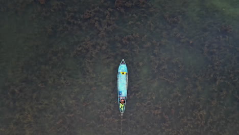 Top-view-of-a-boat-in-the-water-from-a-drone,-birds-eye-view