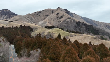 Vuelo-De-Drones-Sobre-Frondosos-árboles-En-Aso,-Prefectura-De-Kumamoto,-Japón,-Mostrando-El-Impresionante-Paisaje-Natural-De-Montañas-Y-Colinas