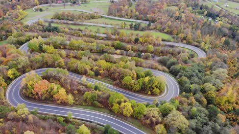 Twisting,-winding-modern-transit-roadway-through-autumn-trees-with-golden-leaves