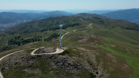 wind-turbine-rotating-on-top-of-a-mountain-overlooking-Gerês,-renewable-wind-energy-portugal