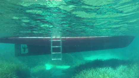 Blick-Auf-Ein-Boot-Unter-Wasser-Unterhalb-Der-Wasserlinie-In-Kristallklarem-Wasser