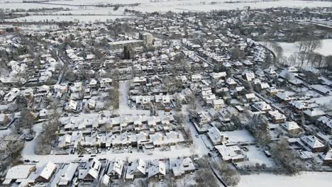 Drone-flying-over-a-beautiful-snow-covered-town-with-a-municipal-water-tower-in-the-center