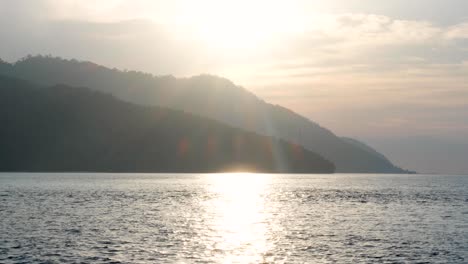 Vista-Panorámica-Del-Paisaje-De-Una-Remota-Isla-Tropical-Con-Una-Hermosa-Luz-Del-Sol-Que-Se-Refleja-Sobre-El-Agua-Del-Océano-En-El-Popular-Destino-Vacacional-De-Raja-Ampat,-Papua-Occidental,-Indonesia