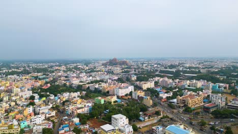 Dicht-Besiedeltes-Indisches-Stadtbild-Von-Tiruchirappalli-Mit-Vielfältiger-Architektur-In-Der-Abenddämmerung-Und-Der-Felsfestung-Malaikottai-Im-Hintergrund
