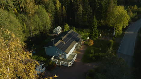 Aerial-view-tilting-toward-a-solar-powered-house,-sunny,-autumn-evening
