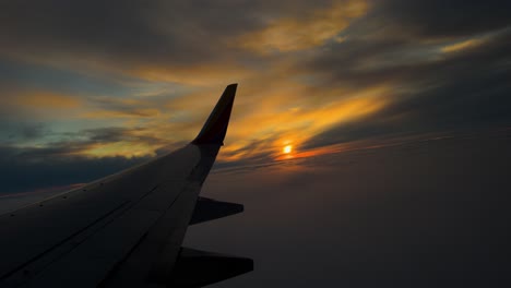 Blick-Aus-Dem-Flugzeugfenster-Mit-Dynamischem-Sonnenuntergang-Während-Des-Fluges