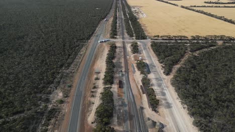 Grain-cargo-truck-driving-along-rural-road-near-storage-and-distribution-center,-Western-Australia