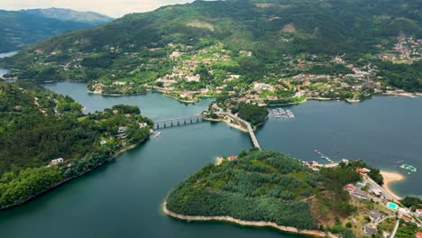 Aerial-Footage-of-Caniçada's-Bridge-Over-Caldo-River,-Gerês,-Northern-Portugal,-bathed-in-Sunshine-with-Reflective-Lake-Views