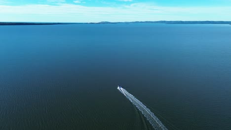Drone-aerial-boat-in-Tuggerah-Lakes-catchment-water-sea-with-coastline-bushland-Toukley-Noraville-Gorokan-ramp-Central-Coast-marine-transport-Australia