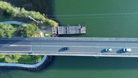 Drone-aerial-pan-of-cars-traffic-over-Toukley-bay-bridge-Gorokan-boat-ramp-wharf-Tuggerah-Lake-Central-Coast-infrastructure-Australia