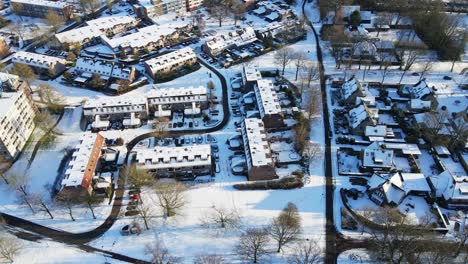 Cinematic-aerial-of-a-small-snow-covered-community-in-a-rustic-town-in-the-Netherlands
