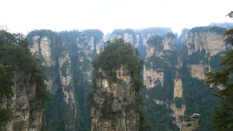 Misty-Avatar-Hallelujah-mountain-peaks-in-Zhangjiajie-National-Park-with-lush-greenery,-likely-shot-during-the-day,-aerial-view