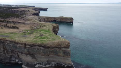 Wide-drone-shot-of-300ft-cliffs-with-water-below