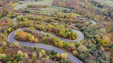 Curved,-winding-modern-roadway,-asphalt-country-road-in-rural-autumn-landscape