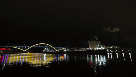 Cargo-ship-moving-under-the-Daniel-Hoan-Memorial-Bridge,-night-in-Milwaukee,-USA