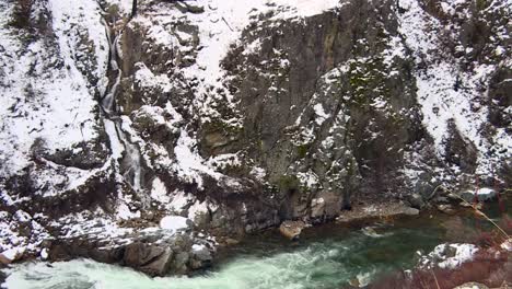 Wasserfall,-Der-Im-Winter-In-Einen-Fließenden-Fluss-Stürzt