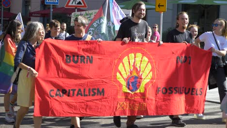 Viernes-Para-Una-Futura-Protesta-Del-FFF-Con-Activistas-Jóvenes-Y-Ancianos-Marchando-Juntos-Mientras-Sostienen-Un-Cartel-Que-Dice-Quemar-Capitalismo,-No-Combustibles-Fósiles-En-Stuttgart,-Alemania
