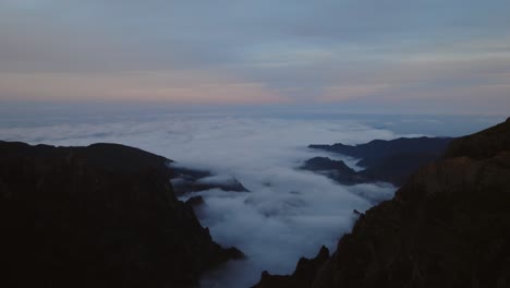 Drone-flying-over-the-clouds-in-the-mountains-after-sunset-when-the-sky-is-colorful-at-Madeira
