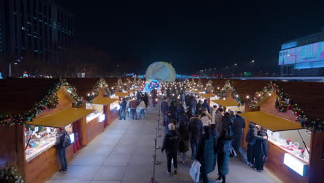 La-Gente-Visita-El-Mercado-Navideño-En-La-Plaza-Gwanghwamun-Por-La-Noche-2023---Vista-Amplia-Y-De-Gran-ángulo
