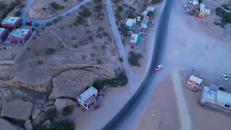 Bird's-eye-view-of-a-winding-highway-road-through-a-rocky-village,-Kund-Malir,-Balochistan,-Pakistan