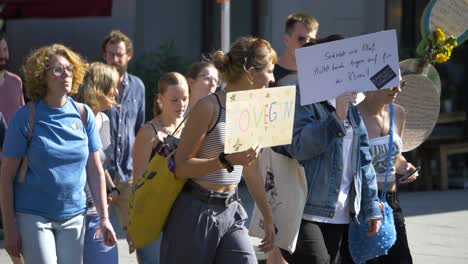 Fridays-for-Future-FFF-protest-by-young-and-elderly-activists-walking-together-and-holding-sign-that-says-go-vegan-in-Stuttgart,-Germany
