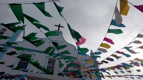 Toma-Exterior-Que-Captura-La-Iglesia-De-Nuestra-Señora-De-La-Luz-Adornada-Con-Una-Vibrante-Variedad-De-Banderas-Multicolores,-Morro-De-Sao-Paulo,-Bahía,-Brasil.