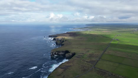 Loophead-with-cliffs-and-fields-meeting-the-Atlantic-Ocean,-a-clear-day,-aerial-view