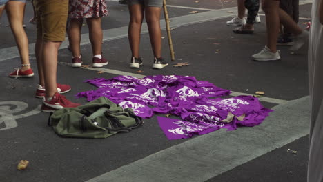 Primer-Plano-De-Pañuelos-Feministas-De-Color-Púrpura-Político-A-La-Venta-En-Una-Manifestación-Sobre-El-Aborto,-El-Vendedor-Ambulante-Los-Está-Vendiendo
